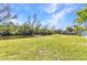 Large backyard overlooking the waterway with a dock and lush landscaping at 312 Darst Ave, Punta Gorda, FL 33950