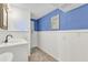 Bathroom with blue accent wall, tile floors, and a decorative beach themed wall decoration at 312 Darst Ave, Punta Gorda, FL 33950