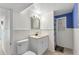 Bright bathroom featuring a vanity, mirror, toilet, and walk-in shower with a blue accent wall at 312 Darst Ave, Punta Gorda, FL 33950