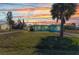 Charming single-story home with lush green lawn and mature trees at sunset at 312 Darst Ave, Punta Gorda, FL 33950