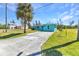 Quaint blue home with a long driveway, a well-maintained lawn and mature palm trees at 312 Darst Ave, Punta Gorda, FL 33950