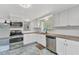 Kitchen featuring white cabinets, granite countertops, and stainless steel appliances at 312 Darst Ave, Punta Gorda, FL 33950