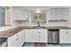Bright kitchen featuring white cabinets, granite countertops, and stainless steel appliances at 312 Darst Ave, Punta Gorda, FL 33950