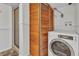 Laundry area featuring a front-load washing machine and a folding partition separating it from a shower at 312 Darst Ave, Punta Gorda, FL 33950