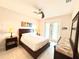 Comfortable bedroom with neutral tones, ceiling fan, and private access to an outdoor balcony for relaxation at 3414 Sandpiper Dr, Punta Gorda, FL 33950