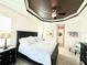 Bright bedroom featuring a tray ceiling, a comfortable queen-sized bed, and decorative artwork at 3414 Sandpiper Dr, Punta Gorda, FL 33950