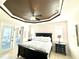 Bedroom with a tray ceiling, a comfortable queen-sized bed, and access to a patio at 3414 Sandpiper Dr, Punta Gorda, FL 33950