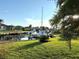 Boats parked on boat lifts along canal and waterfront, with a green grassy lawn in the foreground at 3414 Sandpiper Dr, Punta Gorda, FL 33950