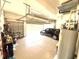 Spacious three car garage with ample storage and parking space featuring car, bikes, water heater, and storage rack at 3414 Sandpiper Dr, Punta Gorda, FL 33950