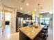 Spacious kitchen featuring stainless steel appliances, granite countertops, and a large island with seating and views of the dining area at 3414 Sandpiper Dr, Punta Gorda, FL 33950