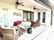 Covered outdoor patio space with ceiling fans, wicker furniture, and sliding glass doors at 3414 Sandpiper Dr, Punta Gorda, FL 33950
