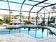 Screened in pool area with in ground pool, brick patio, and view of boats on the canal at 3414 Sandpiper Dr, Punta Gorda, FL 33950