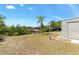Lush backyard with view of the waterway with private dock, and a charming palm tree at 4053 Joseph St, Port Charlotte, FL 33948