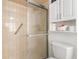 Bathroom featuring a tiled shower, a toilet, and storage shelves, providing a practical and well-organized space at 4053 Joseph St, Port Charlotte, FL 33948
