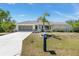 Charming home with well-maintained landscaping, concrete driveway, and a decorative mailbox at 4053 Joseph St, Port Charlotte, FL 33948