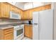 Bright kitchen featuring white appliances and wooden cabinets at 4053 Joseph St, Port Charlotte, FL 33948