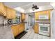 Kitchen with wooden cabinets, white appliances, and ceiling fan at 4053 Joseph St, Port Charlotte, FL 33948