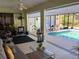Inviting screened-in porch with comfortable seating, ceiling fan, view of pool and outdoor scenery at 4053 Joseph St, Port Charlotte, FL 33948