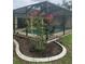 Enclosed porch with screen, overlooking a lush garden and pool with decorative chairs and pink flowers at 4053 Joseph St, Port Charlotte, FL 33948