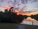 Scenic sunset view over the calm water, reflecting colorful clouds and lush trees, creating a serene landscape at 4053 Joseph St, Port Charlotte, FL 33948