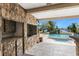 Outdoor kitchen featuring a stone facade and views of the pool and waterway at 4438 Meager Cir, Port Charlotte, FL 33948