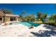 Outdoor pool with brick trim surrounded by tropical landscaping, lawn, and home with sliding door on a bright sunny day at 4438 Meager Cir, Port Charlotte, FL 33948