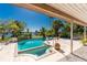 An inviting outdoor pool and spa with lush tropical landscaping and waterfront views on a sunny day at 4438 Meager Cir, Port Charlotte, FL 33948