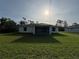 View of the home's exterior, lanai, and lawn from the backyard on a sunny day at 5342 Wagon Wheel Dr, North Port, FL 34291