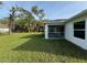 A view of the screened lanai from the backyard shows the home's windows and white exterior at 5342 Wagon Wheel Dr, North Port, FL 34291