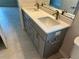 Bathroom featuring double sinks with quartz countertop, gray cabinets, and modern fixtures at 5342 Wagon Wheel Dr, North Port, FL 34291