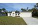 Charming single-story home with a well-manicured lawn, attached two-car garage, and a modern exterior at 5342 Wagon Wheel Dr, North Port, FL 34291