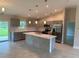 Modern kitchen with gray cabinets, stainless steel appliances, and a central island with sink and quartz countertops at 5342 Wagon Wheel Dr, North Port, FL 34291