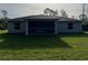 Exterior of the home displays a neatly maintained backyard with lush grass and a screened-in patio for outdoor living at 5354 Wagon Wheel Dr, North Port, FL 34291