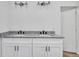 Bathroom featuring a double vanity with granite countertops, dark hardware, and globe lighting at 551 Crandall Nw St, Port Charlotte, FL 33952
