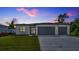 Modern home featuring a three-car garage and freshly laid lawn at 551 Crandall Nw St, Port Charlotte, FL 33952
