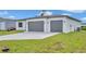 New construction home featuring a two-car garage and modern design in a well-maintained lawn at 551 Crandall Nw St, Port Charlotte, FL 33952