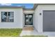 Modern home featuring a glass front door and manicured front lawn at 551 Crandall Nw St, Port Charlotte, FL 33952