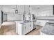 Open kitchen with granite island, stainless steel appliances, and modern pendant lighting, flowing into living space at 551 Crandall Nw St, Port Charlotte, FL 33952