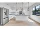 Bright kitchen showcases white cabinets, a granite-topped island, pendant lights, and stainless appliances at 551 Crandall Nw St, Port Charlotte, FL 33952
