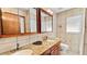 Well lit bathroom with double sinks, granite countertop, tile flooring, and wooden cabinets at 5705 44Th E Ave, Bradenton, FL 34203