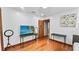 The bedroom has wood floors, white walls, and contains a flat screen TV on a black table at 5705 44Th E Ave, Bradenton, FL 34203