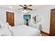 Modern bedroom with mounted TV, ceiling fan, and minimalist decor at 5705 44Th E Ave, Bradenton, FL 34203