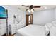 Bright bedroom featuring white walls, wood floors, ceiling fan, and modern white dresser with a round mirror at 5705 44Th E Ave, Bradenton, FL 34203