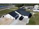 Aerial view of home featuring a dark roof, an attached garage and a paved driveway with a black SUV at 5705 44Th E Ave, Bradenton, FL 34203