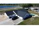 Aerial view of a single-story home with a dark roof, pool and a driveway with a black car at 5705 44Th E Ave, Bradenton, FL 34203