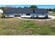 Single-story home with an attached garage, a dark roof and decorative landscaping with a walkway at 5705 44Th E Ave, Bradenton, FL 34203