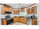 Charming kitchen featuring oak cabinets, granite countertops, stainless steel appliances, and tile flooring for a classic look at 5705 44Th E Ave, Bradenton, FL 34203