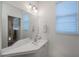 Bright bathroom features a large mirror, a stylish vanity and a window with privacy blinds at 5733 White Jasmine Way, North Port, FL 34287