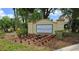 Welcoming Lakeside Greens community sign with beautiful flowerbed and lush landscaping at 5733 White Jasmine Way, North Port, FL 34287