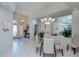 Bright dining room featuring a glass table, white chairs, and stylish chandelier at 5733 White Jasmine Way, North Port, FL 34287
